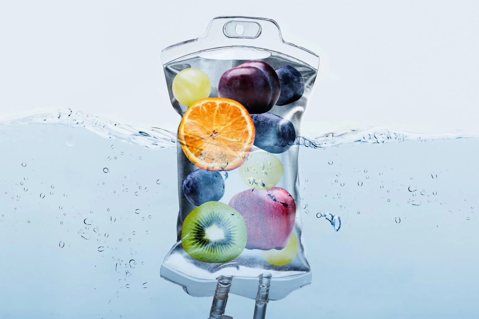 A bag of fruit is floating in the water.